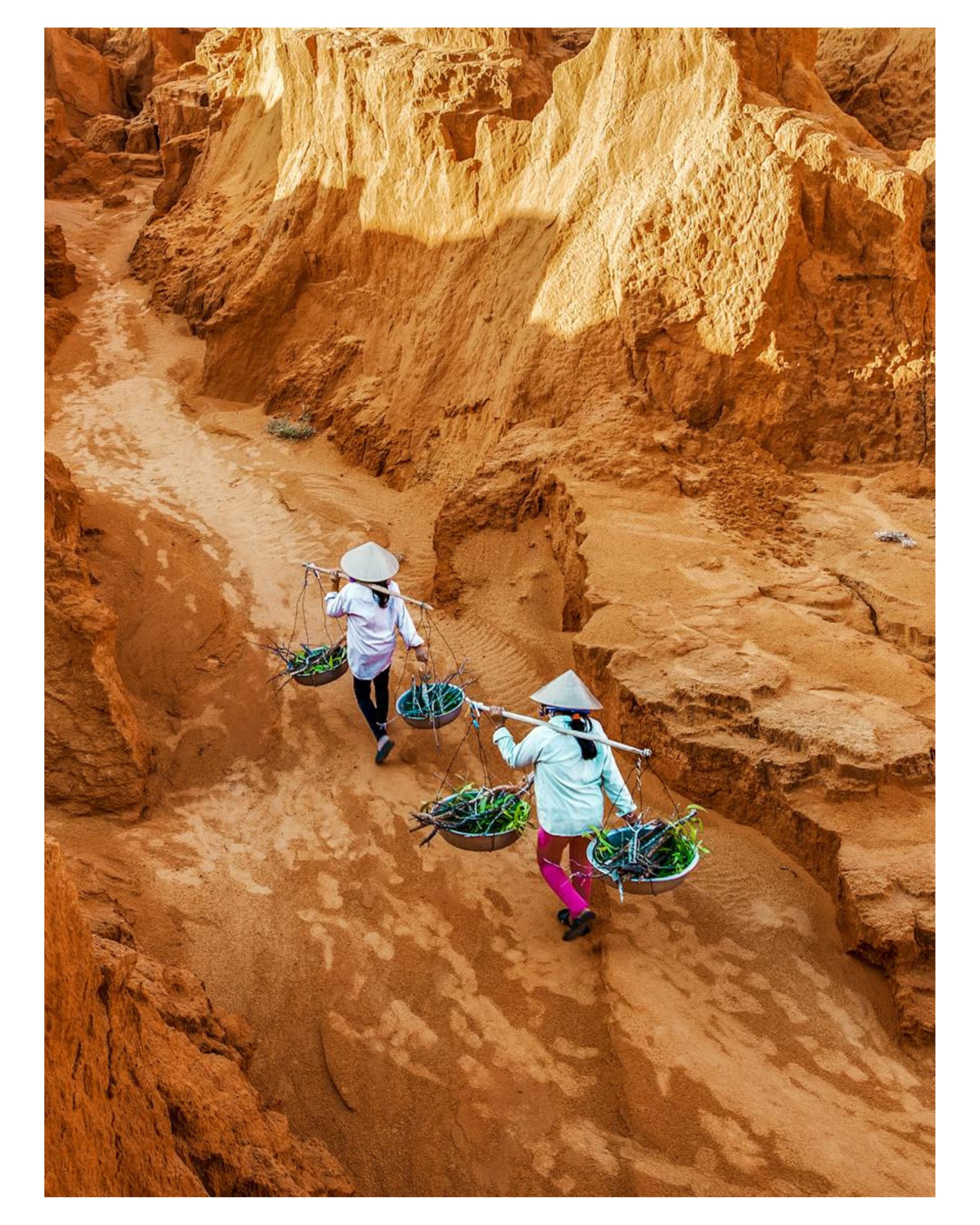 Farmers Walking Through Red Sand Dunes in Vietnam