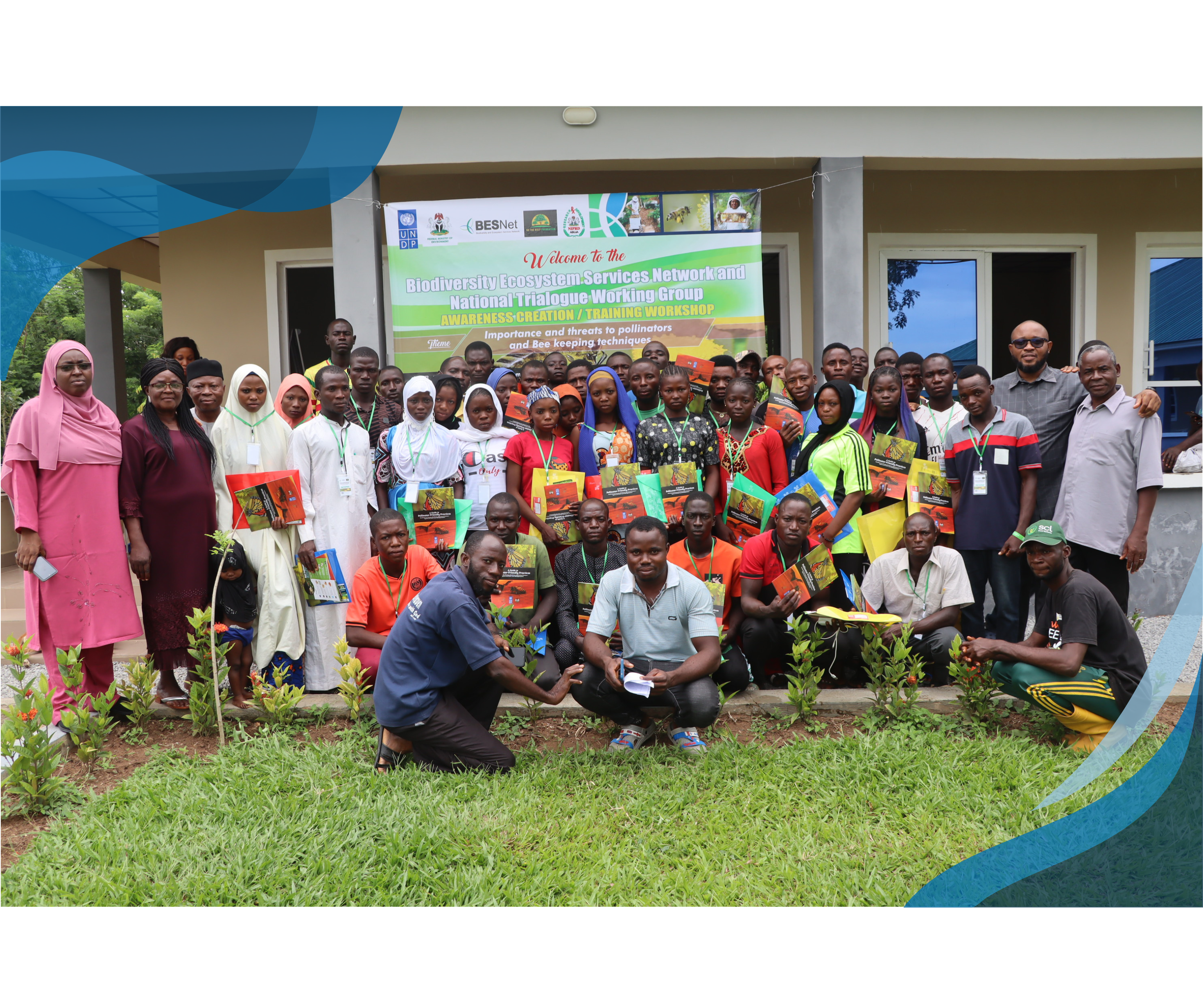 A group of people posing for a group photo in front of a building, holding informational materials at a Biodiversity Ecosystem Services Network and National Trialogue Working Group workshop.