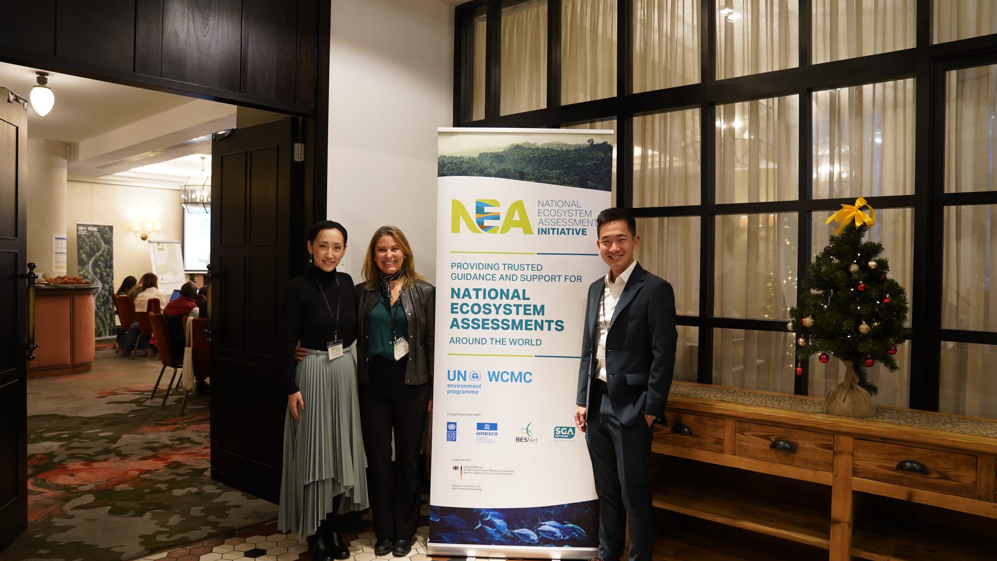 Participants posing beside the event poster