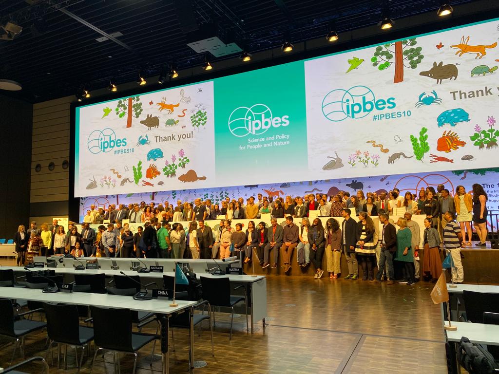 Group photo of the Stakeholder Day attendees with an IPBES poster at the background