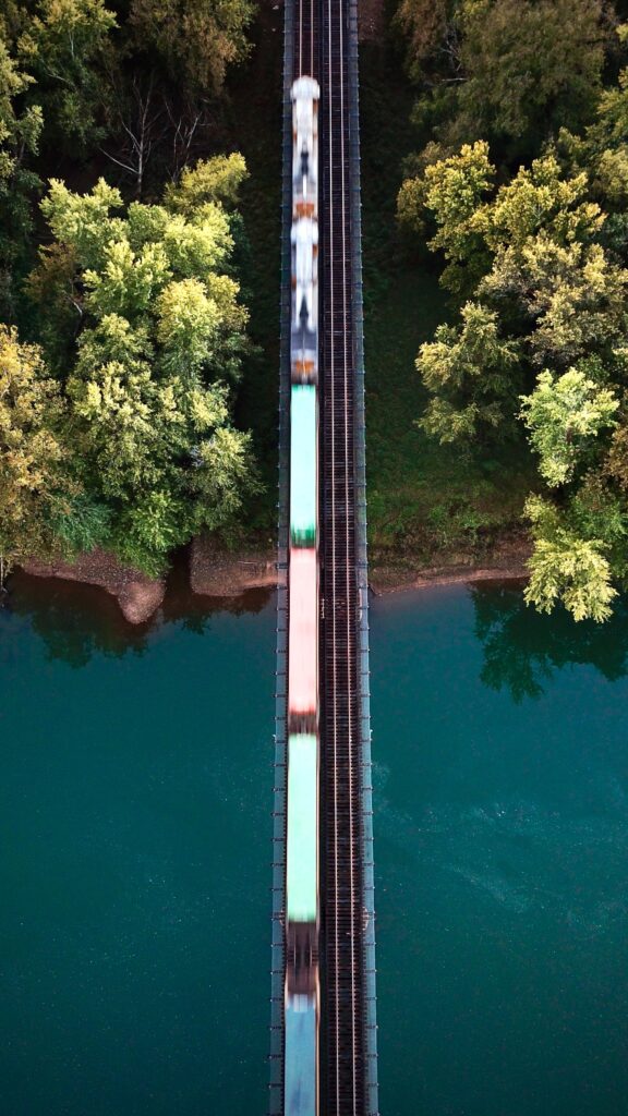 A train crossing a river to reach a forest