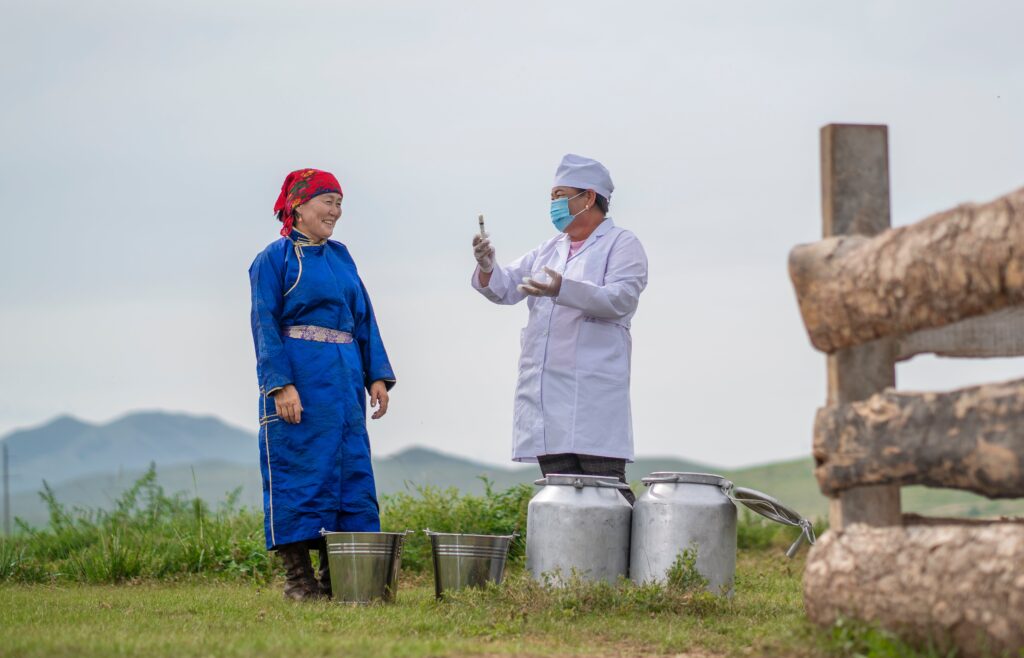 Image of a woman Mongolian farmer and a scientist situated at a farm