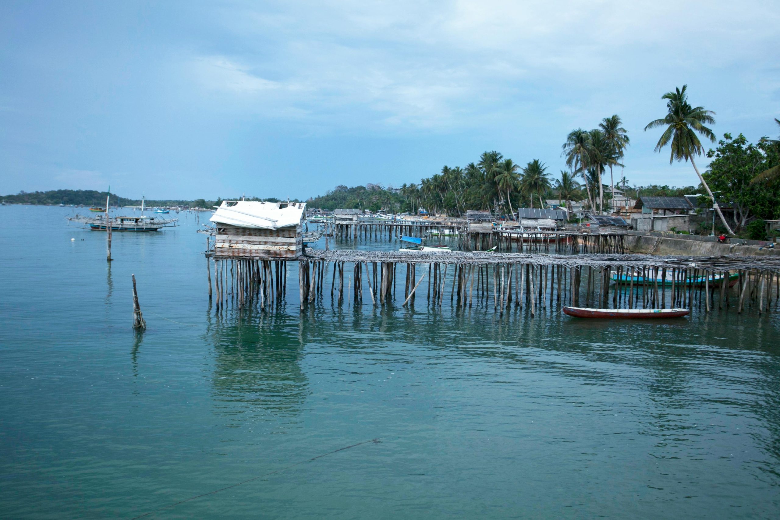stilt houses and boats on tropical shoreline