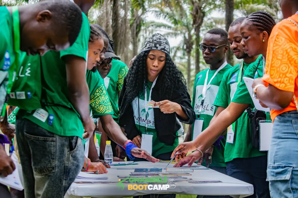 Young participants at the 2025 Gnambêlê Bootcamp gather around a table during a hands-on group activity.